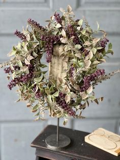 a vase filled with purple flowers sitting on top of a table