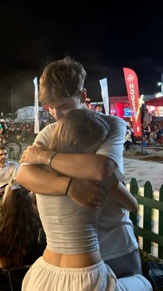 two people hugging each other in front of a crowd