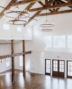 an empty room with wooden beams and chandeliers