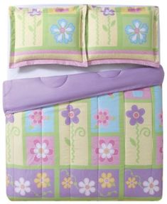 a child's bed with purple and green flowers on the comforter, sheets and pillowcases