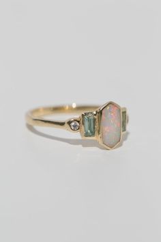 Art deco inspired ring with Australian opal, with either aquamarine and diamonds, or rubies. The opal is inlaid into the elongated hexagon, measuring 9.5mm x 5mm. Accent aquamarine and diamonds are approximately .30 total carat worth. Millimeter measurement from end to end is 15mm. Your choice of gold color and karat. The band is 1.75mm thick. Please leave a note at checkout with your preferred size. All gems and rocks are nuanced in color, please know that your ring will be very similar to the Opal Accent Engagement Ring, Inlaid Opal Ring, Opal Diamond Ring Engagement, Hexagon Opal Ring, Aquamarine Opal Engagement Ring, Diamond Opal Ring, Aquamarine Rings Vintage, Opal Engagement Ring White Gold, Opal And Aquamarine Ring