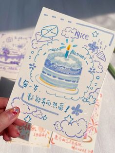 a person holding up a card with a birthday cake on it