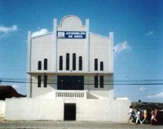 people walking in front of a white building