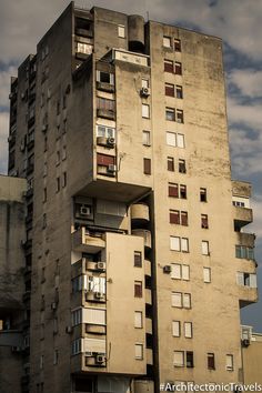 an old building with windows and balconies against a cloudy sky