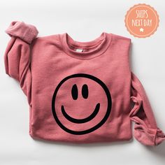 If you're looking for a thoughtful and practical gift, our apparel is sure to be appreciated by anyone who receives it. These happy face sweatshirts are handmade to order on an ultra-soft crewneck that will quickly become your go-to apparel item! Our trendy happy hoodies are made with eco-friendly water-based ink that feels good and lasts longer! You will never want to take it off! ♥Sizing info♥ *Unisex sizing. *Order your true size for a more fitted feel. Size up for a slouchier look ♥Care Instructions♥ *Wash on cold *Hang dry or tumble dry on low heat *Non-chlorine bleach only *Do not iron directly on the design ♥Shipping♥ 🚚Every order (no matter how large) ships same or next business day! We want you to receive your garment as quickly as you can so you can start enjoying it! 📦Free shi Black Casual Sweatshirt, Casual Black Sweatshirt For Birthday, Casual Cotton Hoodie For Birthday, Casual Winter Birthday Sweatshirt, Pink Winter Sweatshirt For Everyday, Winter Pink Sweatshirt For Everyday, Black Casual Hoodie As Gift, Casual Black Hoodie As Gift, Black Casual Sweatshirt Gift