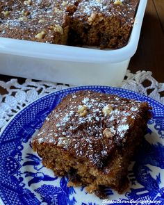 a blue and white plate topped with cake next to a casserole dish filled with baked goods