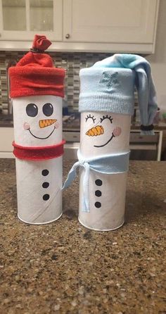 two toilet paper roll snowmen are sitting on the counter