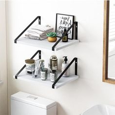 two black metal shelves in a bathroom next to a toilet