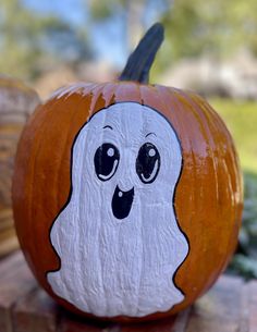 a painted pumpkin with a ghost face on it