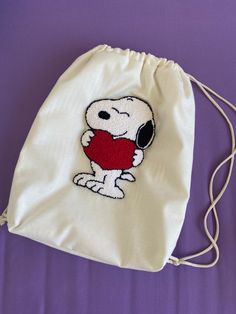 a drawstring bag with a cartoon character holding a heart on it's chest