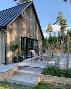 a wooden house with steps leading to the front door and patio area next to it