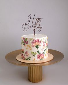 a white and pink birthday cake with flowers on it