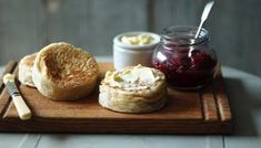 a wooden tray topped with bread and jam