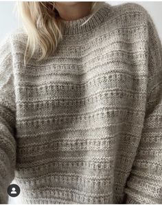 a woman with blonde hair wearing a gray sweater