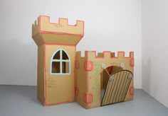 a cardboard castle made to look like it has a door and window on the outside