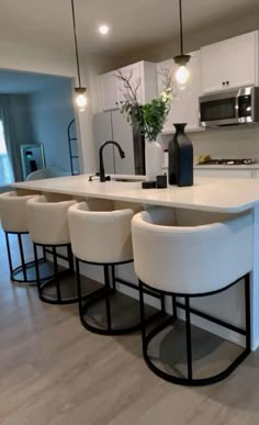 a kitchen with white counter tops and stools