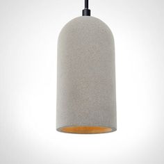 a grey concrete light hanging from a black cord