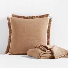 two pillows and a blanket on a white surface