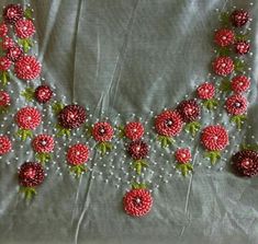 a close up of a piece of cloth with beads and flowers on the top of it