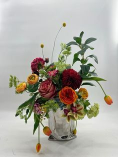 a vase filled with lots of different colored flowers