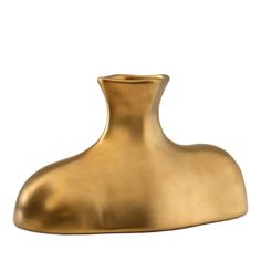 a gold vase sitting on top of a white surface