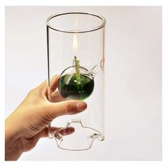 a person holding a wine glass with a candle in it that has been placed inside