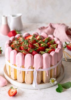 a cake with strawberry icing and strawberries on top