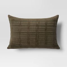 a brown and black striped pillow on a white wall, with the back turned to the side