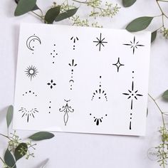 a sheet of paper with different designs on it next to some leaves and flowers in the background