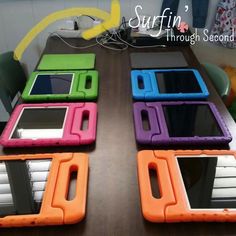 four tablet computers sitting on top of a wooden table