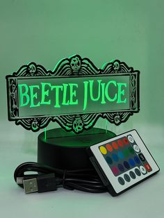 a remote control sitting on top of a table next to a sign that reads beetle juice