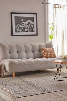 a living room with a couch, coffee table and pictures on the wall above it