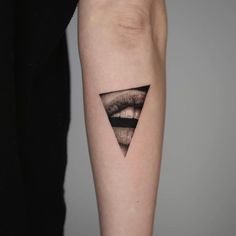 a woman's arm with a triangle tattoo on it