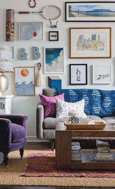 a living room filled with furniture and lots of pictures on the wall above it's coffee table