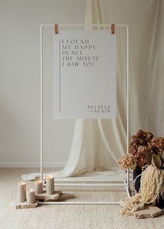 a white sign sitting on top of a floor next to candles