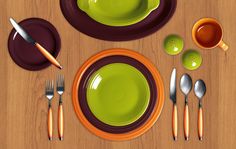 a wooden table topped with yellow plates and silverware