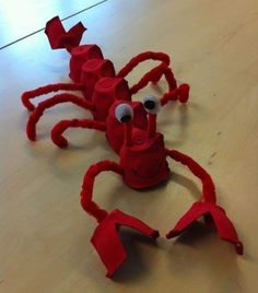 a red crab made out of legos sitting on top of a wooden table