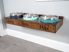 three metal bowls are sitting on a wooden shelf