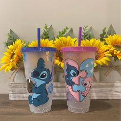 two tumblers sitting next to each other with cartoon characters on them