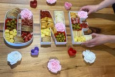 the word love spelled out in letters made from fruit and pastries on a wooden table