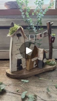 a small wooden house sitting on top of a table next to a window sill