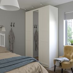 a bedroom with a bed, chair and closet