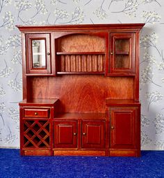 a wooden entertainment center sitting on top of a blue carpeted floor next to a wall