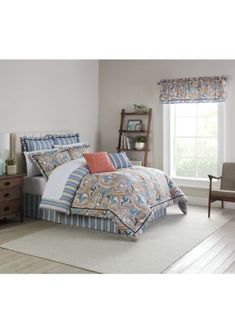 a bed room with a neatly made bed next to a chair and window in it