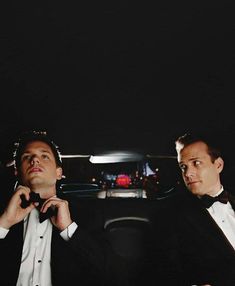 two men in tuxedos sitting next to each other