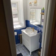 a bathroom with blue and white tile on the floor, sink and toilet in it