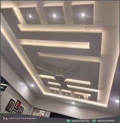 the ceiling in this room is decorated with white lights and recessed lighting, along with a fan