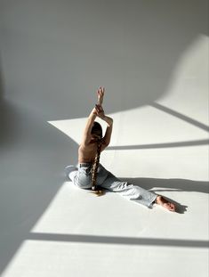 a person sitting on the ground with their hands in the air