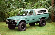 a green pick up truck parked in the grass