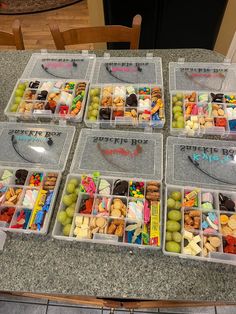 four plastic containers filled with different types of food on top of a kitchen countertop